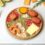 A rustic, live-edge wooden platter displaying an assortment of cheeses and crackers.